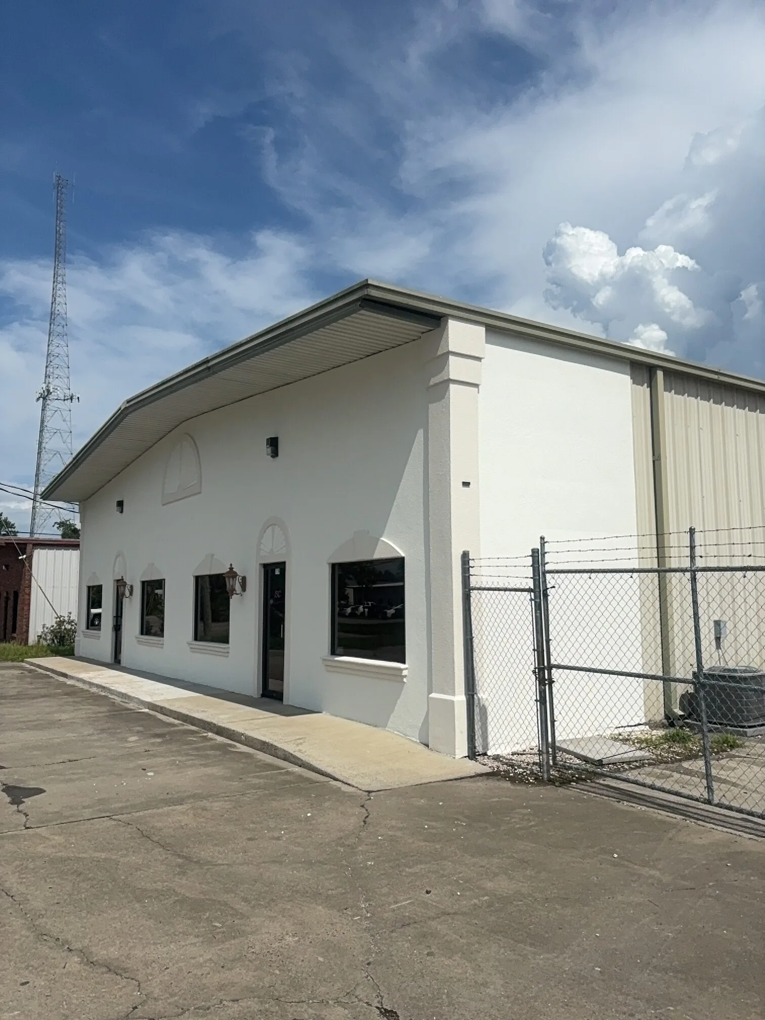 Finished commercial building exterior with freshly painted white walls, trim, window surrounds, and architectural details.