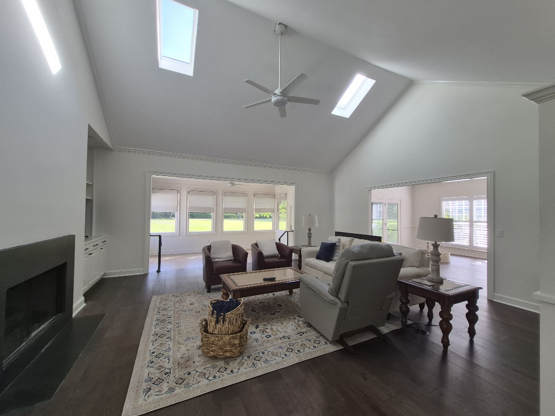 White living room with vaulted ceiling and skylights painted by D&D Decorators