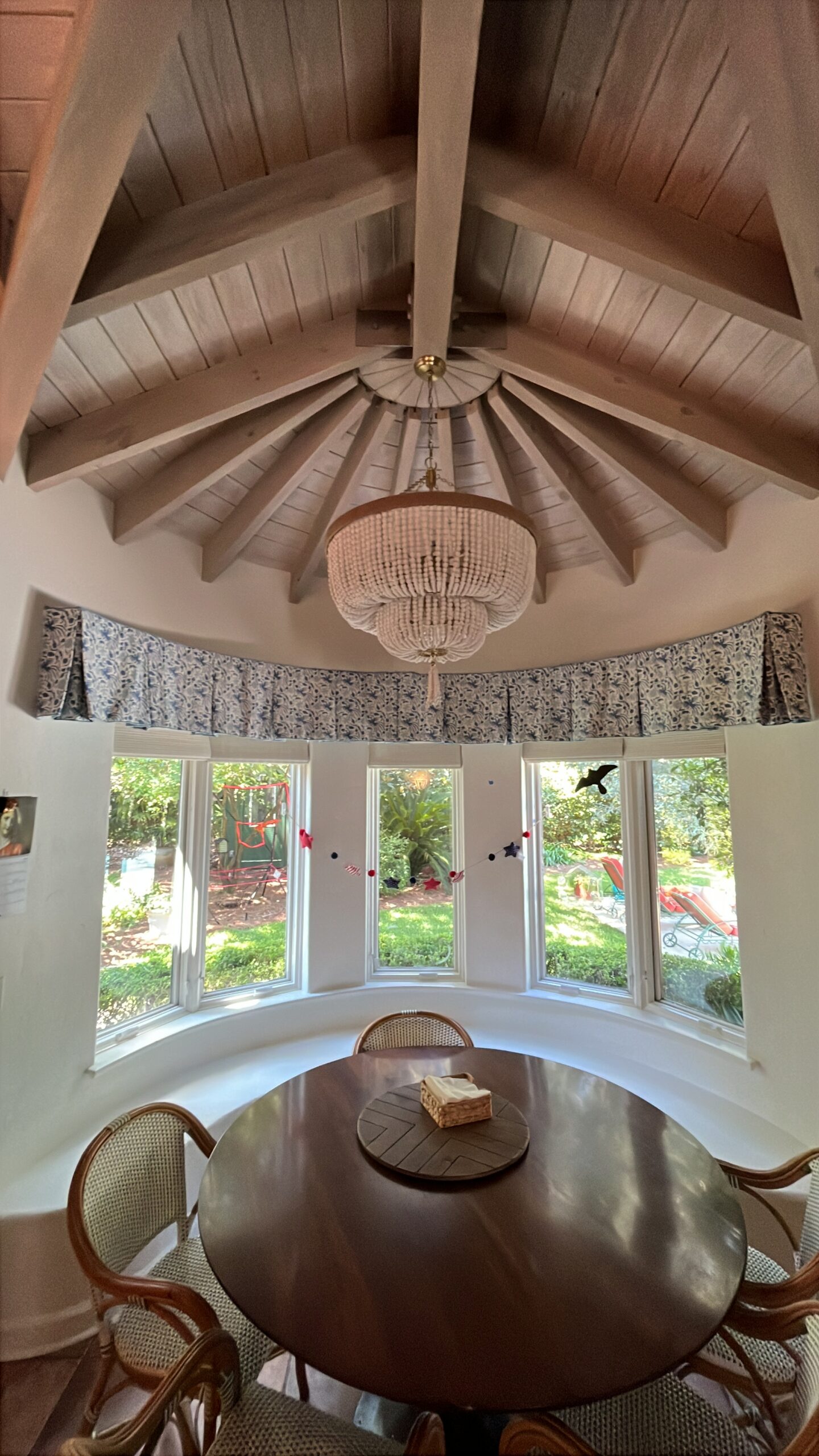 Breakfast nook with painted plank ceiling and curved bay windows