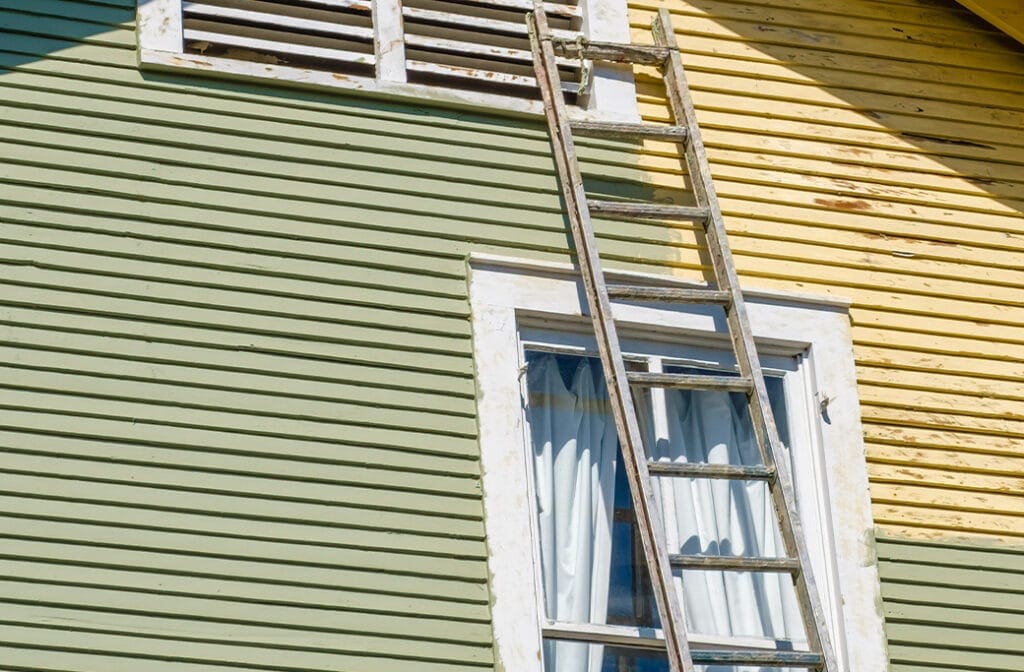 Brunswick GA Oak Grove Island Ladder against a house with green and yellow lap siding and white window trim