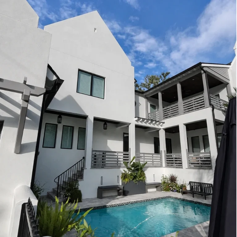 Fresh white exterior finish creates a bright, clean backdrop for this private residential pool courtyard.