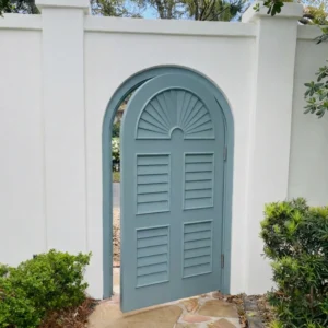 Painted arched garden gate in a stucco wall