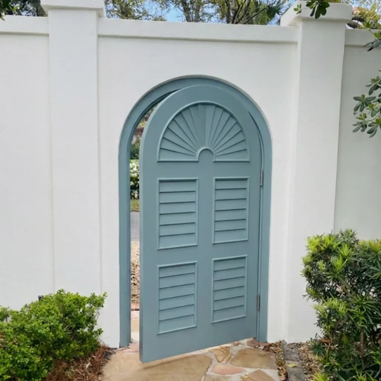 Painted arched garden gate in a stucco wall
