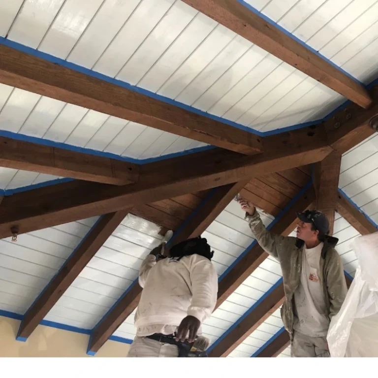 Painters refinishing wood ceiling beams