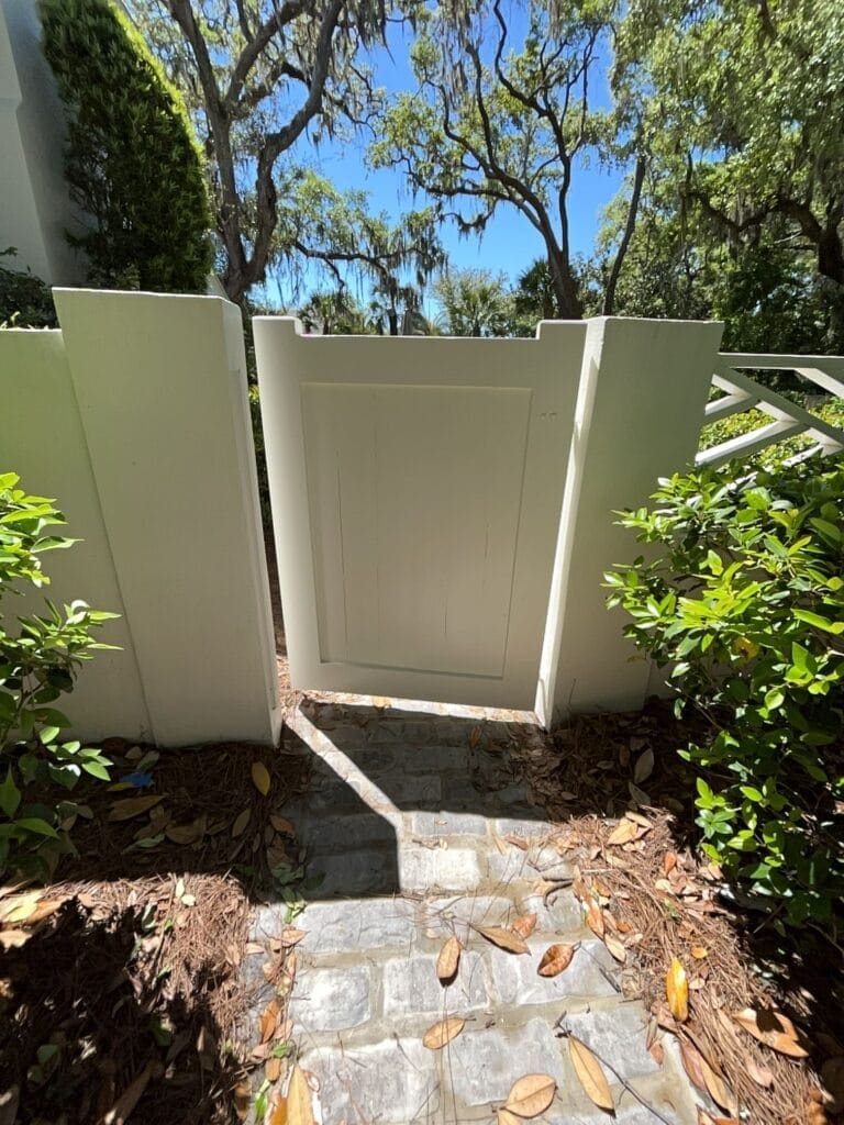 White painted garden gate between stucco walls on a St. Simons Island property