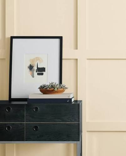Southern Home Trends Cream board-and-batten wall with framed art above a black dresser