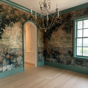 Scenic landscape mural wallpaper with teal painted trim, arched doorway and decorative chandelier.