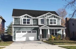 Oak Grove Island Two-story house with blue-gray siding, white trim and a white garage door