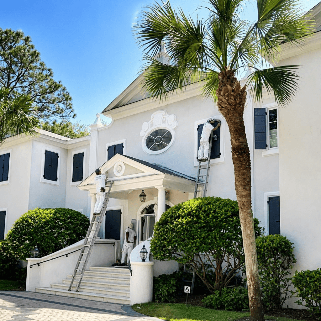 Sea Palms Saint Simons Island White two-story stucco home with black shutters, front steps and a palm tree
