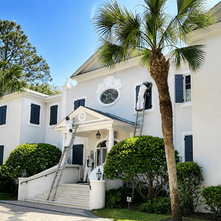 White two-story stucco home with black shutters, front steps and a palm tree